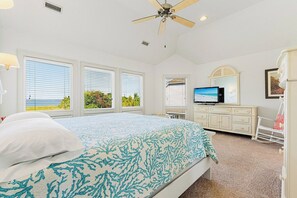 A bedroom with a bed, a television, a dresser, and a rocking chair. - Casa del Sol Soundfront Currituck Club (Corolla)