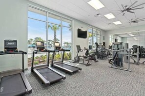 Une salle de sport équipée de tapis de course, de vélos elliptiques et de matériel de musculation.
