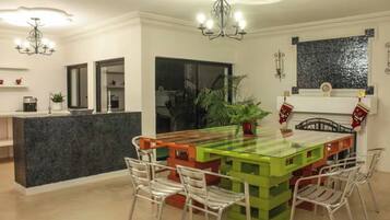 A modern kitchen with a central island, bar stools, and pendant lighting.