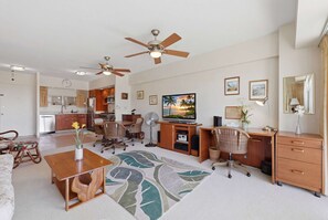 A modern living room with a dining area, kitchen, and a ceiling fan. - Waikiki Oceanfront with FREE Parking & AC (Honolulu)