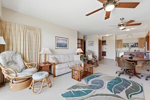 A spacious living room with a sofa, chairs, a coffee table, and a ceiling fan. - Waikiki Oceanfront with FREE Parking & AC (Honolulu)