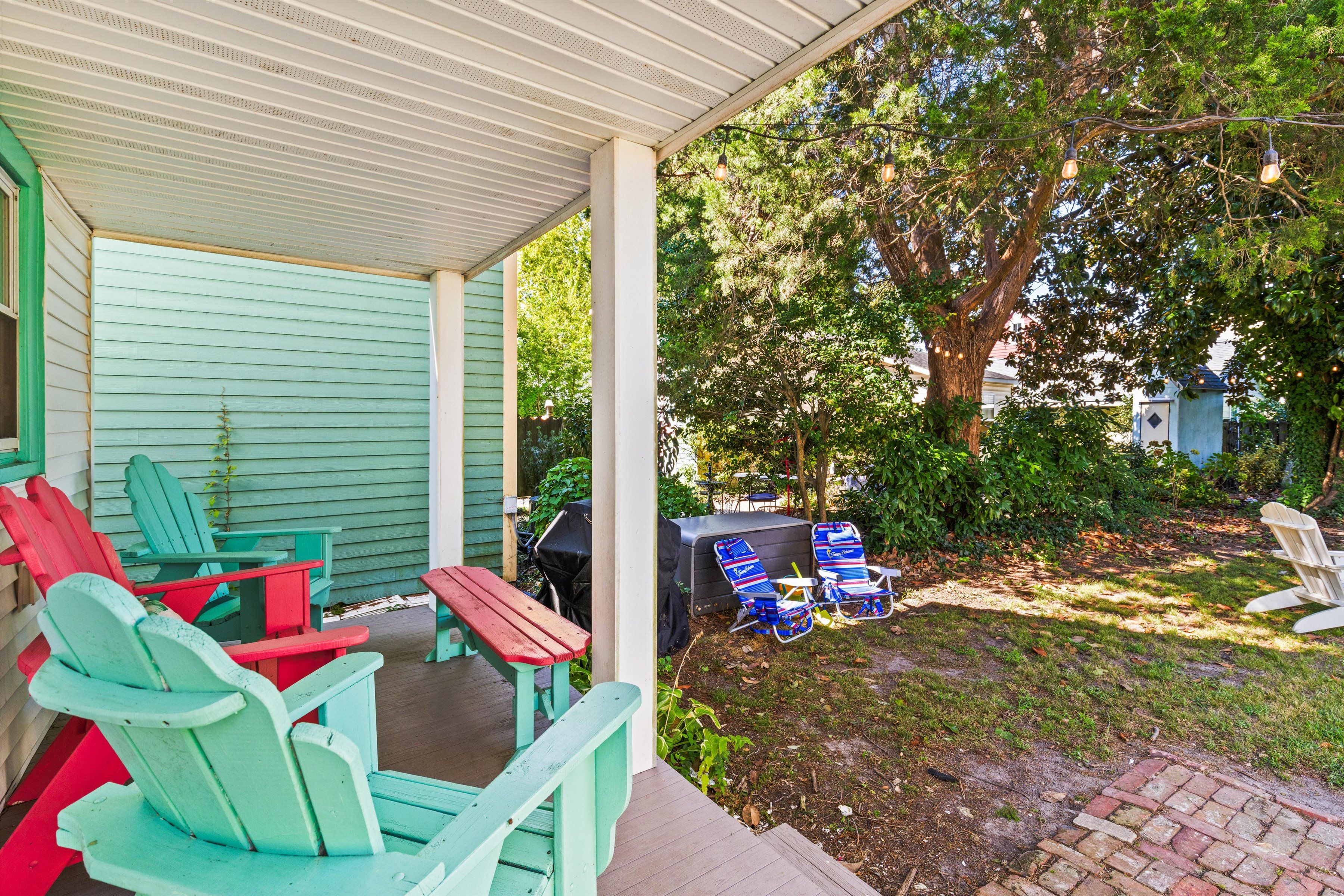A covered porch with outdoor seating and a barbecue grill.