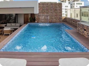 A rectangular hot tub with a tiled edge, surrounded by a wooden deck. - Stylish 1-Bedroom Apartment in the Heart of Santo Domingo (Santo Domingo)