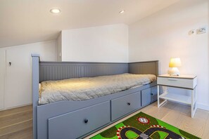 Ein Schlafzimmer mit Bett, Nachttisch und Teppich.