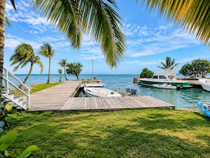 A wooden dock extending into calm waters with boats moored at the end. - Kaneohe Bay 2BR - Oceanfront Pier & Kayaks - Wi-Fi (Kaneohe)