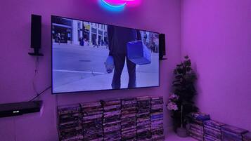 Una stanza con una televisione fissata al muro, circondata da una collezione di DVD.