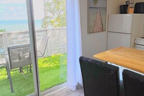 Quarto com vista para o mar, uma mesa de madeira e uma cadeira.