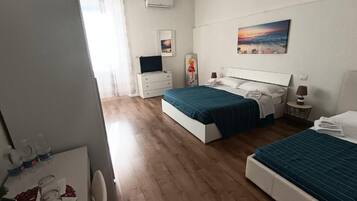 Un dormitorio con dos camas, un escritorio, una silla y una ventana con cortinas.