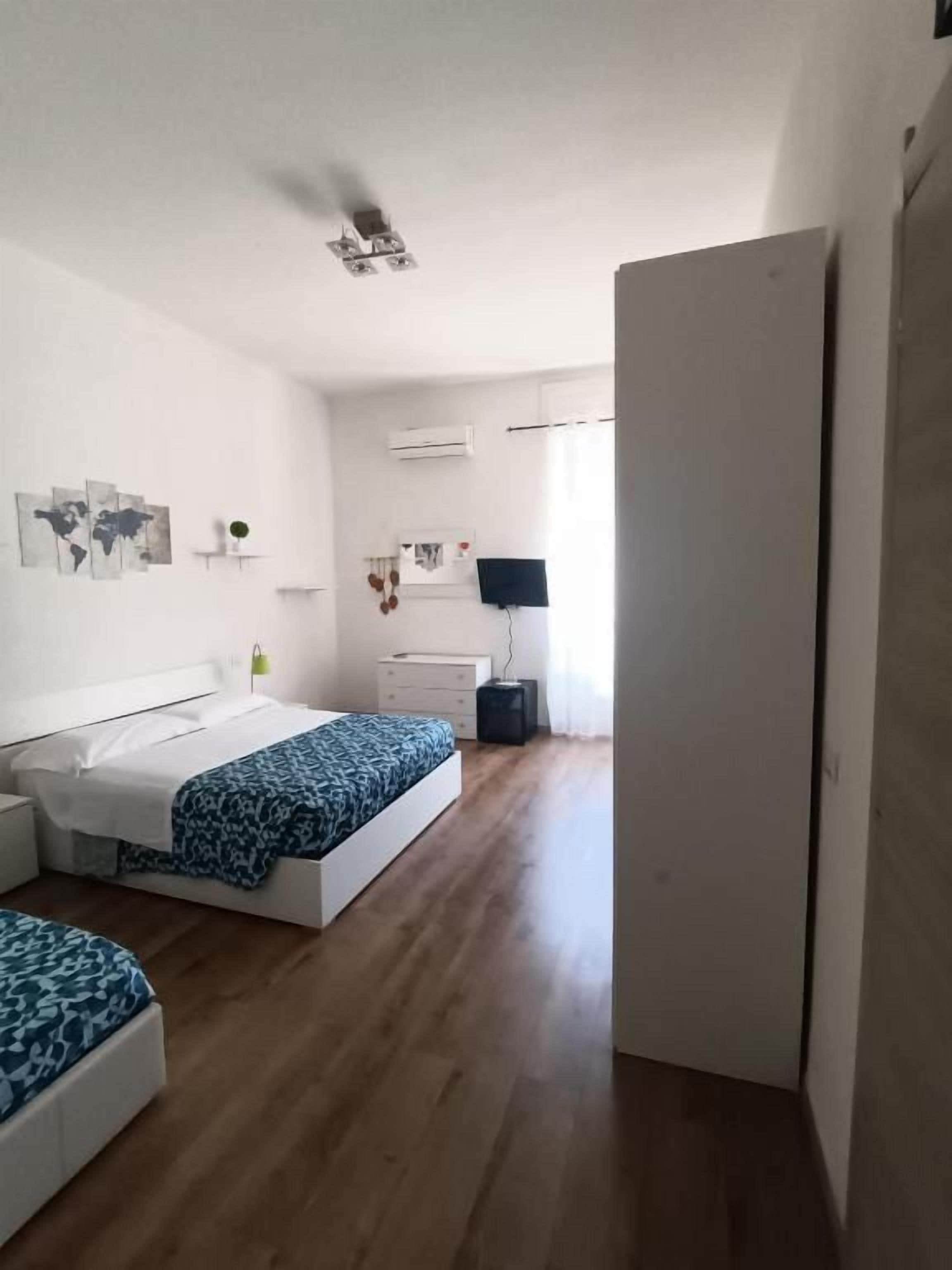Een slaapkamer met een bed, nachtkastje en een garderobe.