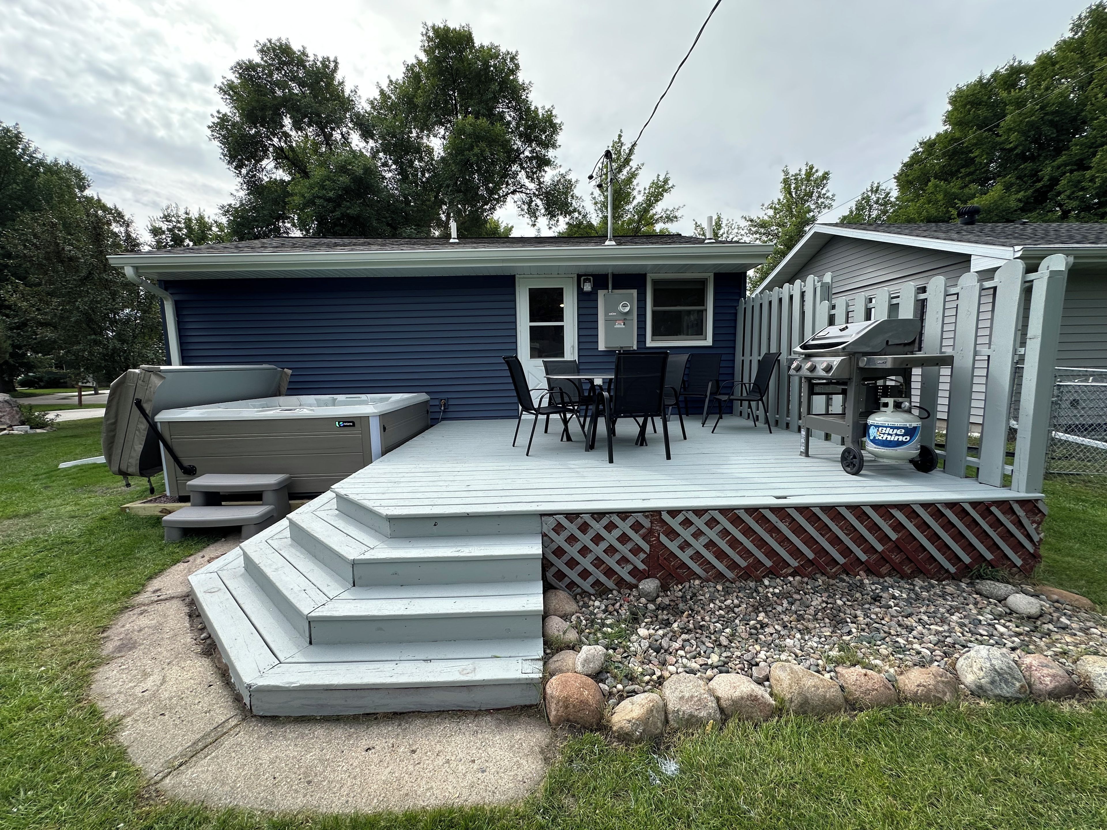 Une terrasse aménagée avec des meubles d’extérieur, un jacuzzi et un espace barbecue.