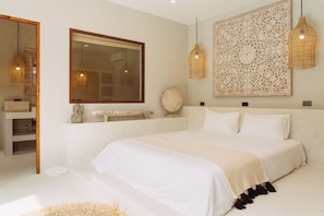 A bedroom with a large bed, a mirror, and decorative wall art. - Villa Pearl — Easy Island Living, Your Way (Ko Samui District)