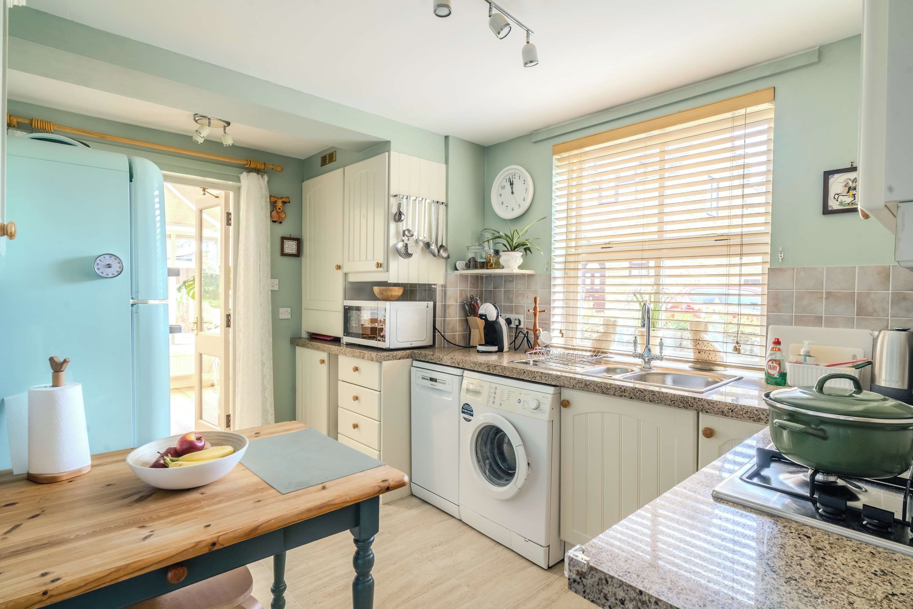 A kitchen with a washing machine, a stove, and a sink.