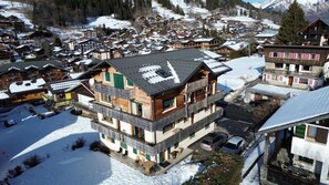 A multi-story building with balconies, a ski resort in the background, and a snow-covered landscape. - 300m from ski slopes, 2nd floor, balcony, tv, ski locker, 47m², Les Gets (Les Gets)