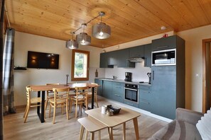 A modern kitchen with a dining area, wooden ceiling, and built-in appliances. - 300m from ski slopes, 2nd floor, balcony, tv, ski locker, 47m², Les Gets (Les Gets)