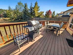 An outdoor deck with a grill, a glass table, and chairs. - McCall Mountain Escape | Loft, Deck & Ping Pong (McCall)