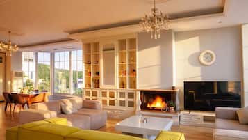 A spacious living room with a fireplace, a yellow sofa, and a television.