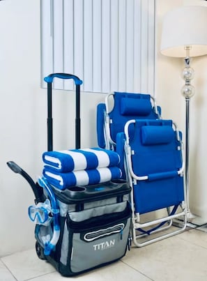 Gepäck eines Reisenden, ein blau-weiß gestreiftes Handtuch und ein blauer Rollstuhl.