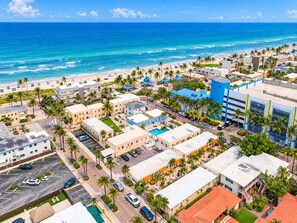 A coastal cityscape with a beach, palm trees, and buildings with a mix of architectural styles. - Beachside Studio I Pool I Full Kitchen (Hollywood)