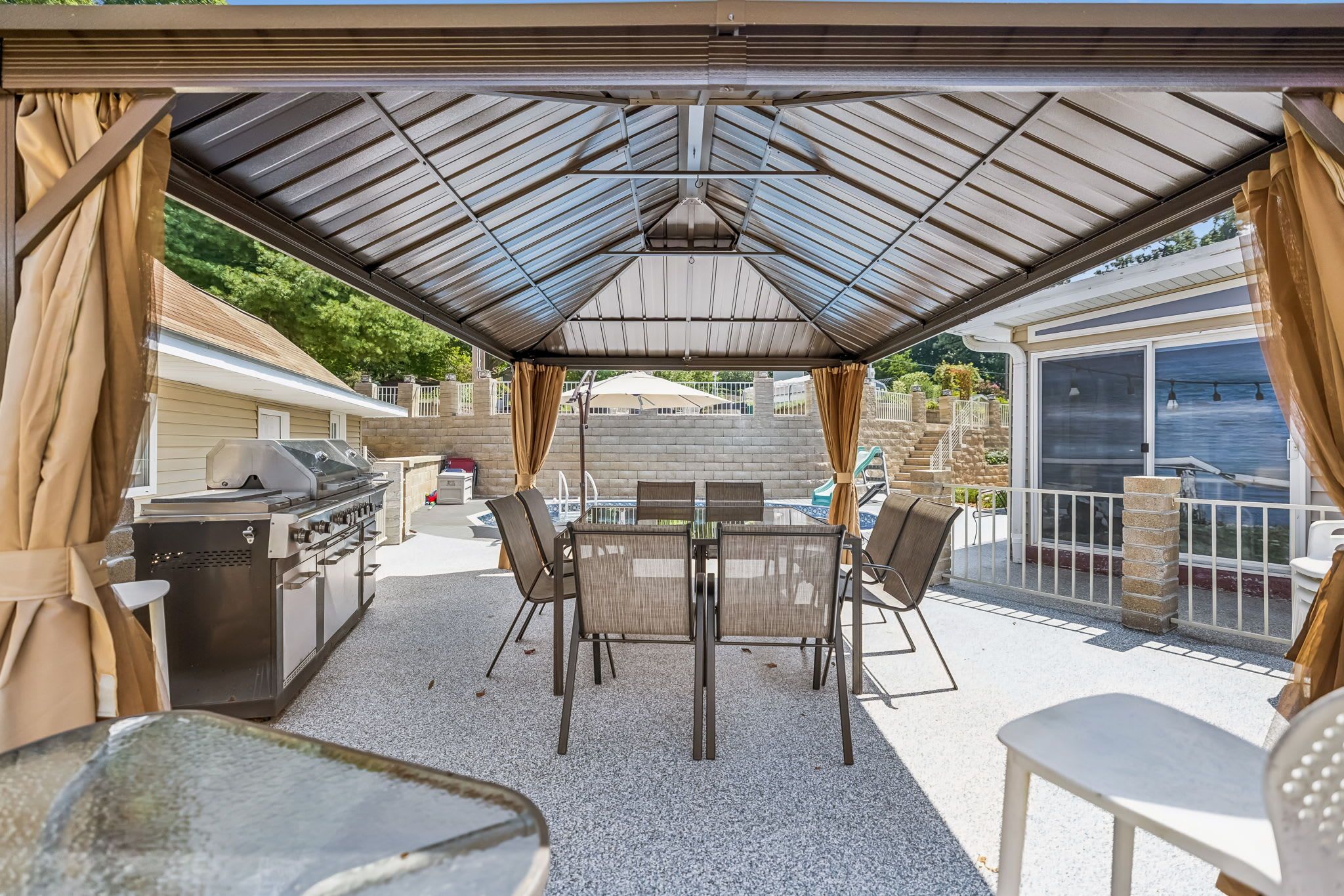 Pool Area: Spend sunny days by the swimming pool complete with comfortable seating, a BBQ grill, chairs, and a table for easy outdoor dining and fun.