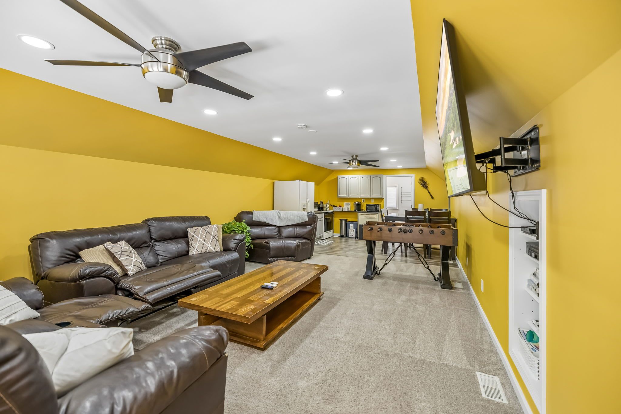 A living room with a sofa, coffee table, and ceiling fan.