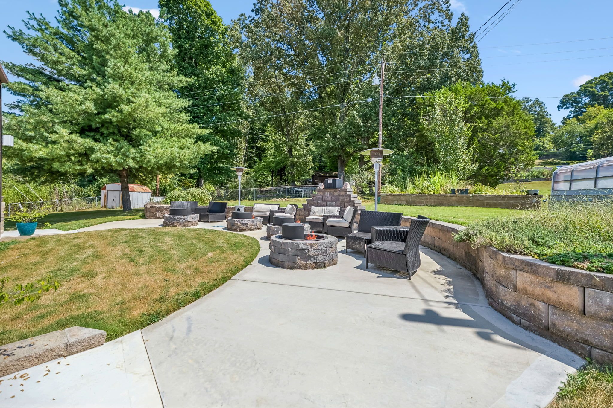 An outdoor patio area with stone seating and a fire pit.