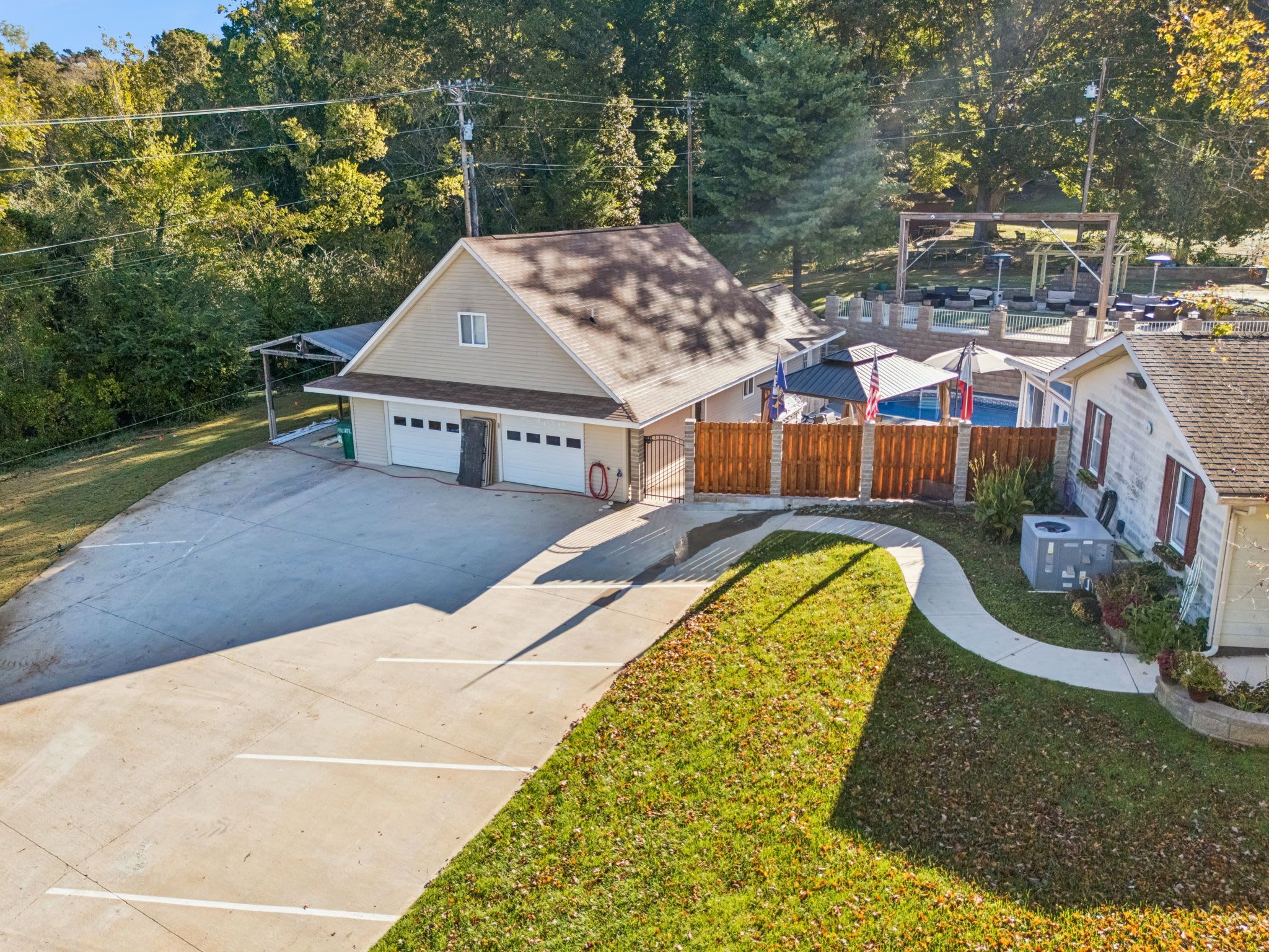 A residential property with a garage, a fenced backyard, and a swimming pool.