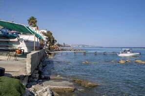 Una propietat a primera línia de mar amb un mur de pedra, un petit moll i vista despejada al mar.