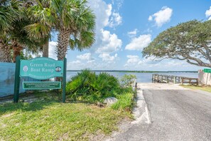 A sign for St. Johns County Green Road Boat Ramp with a view of a body of water and a dock. - Sand, Surf & Fun / Across the street from Beach + Pool & Boat Parking (St. Augustine)