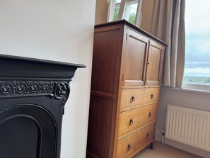 A room with a fireplace, wooden cabinet, and a window with a view. - Gorgeous 3-bedroom townhome on Endcliffe Park (Sheffield)