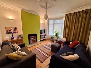 Una sala de estar con chimenea, televisor y sofá.