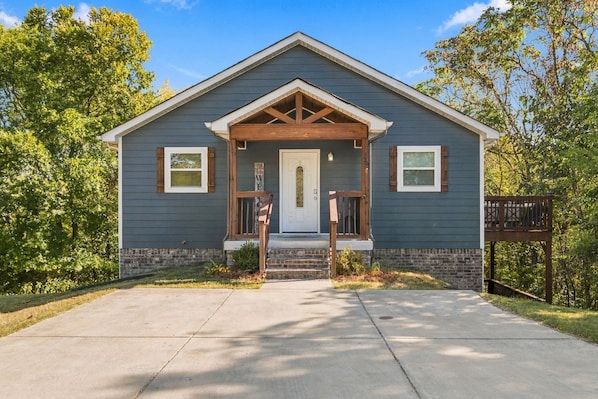 A two-story house with a front porch, a mailbox, and a small garden area. - Treetop House - Private Hillside Escape Near Nashville w/ Game Room, Sleeps 16 (Goodlettsville)