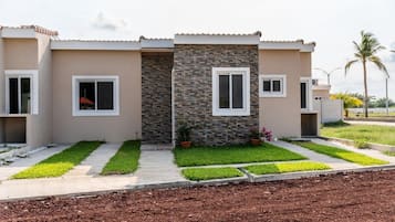 A modern two-story house with a stone facade, a front porch, and a well-maintained lawn.