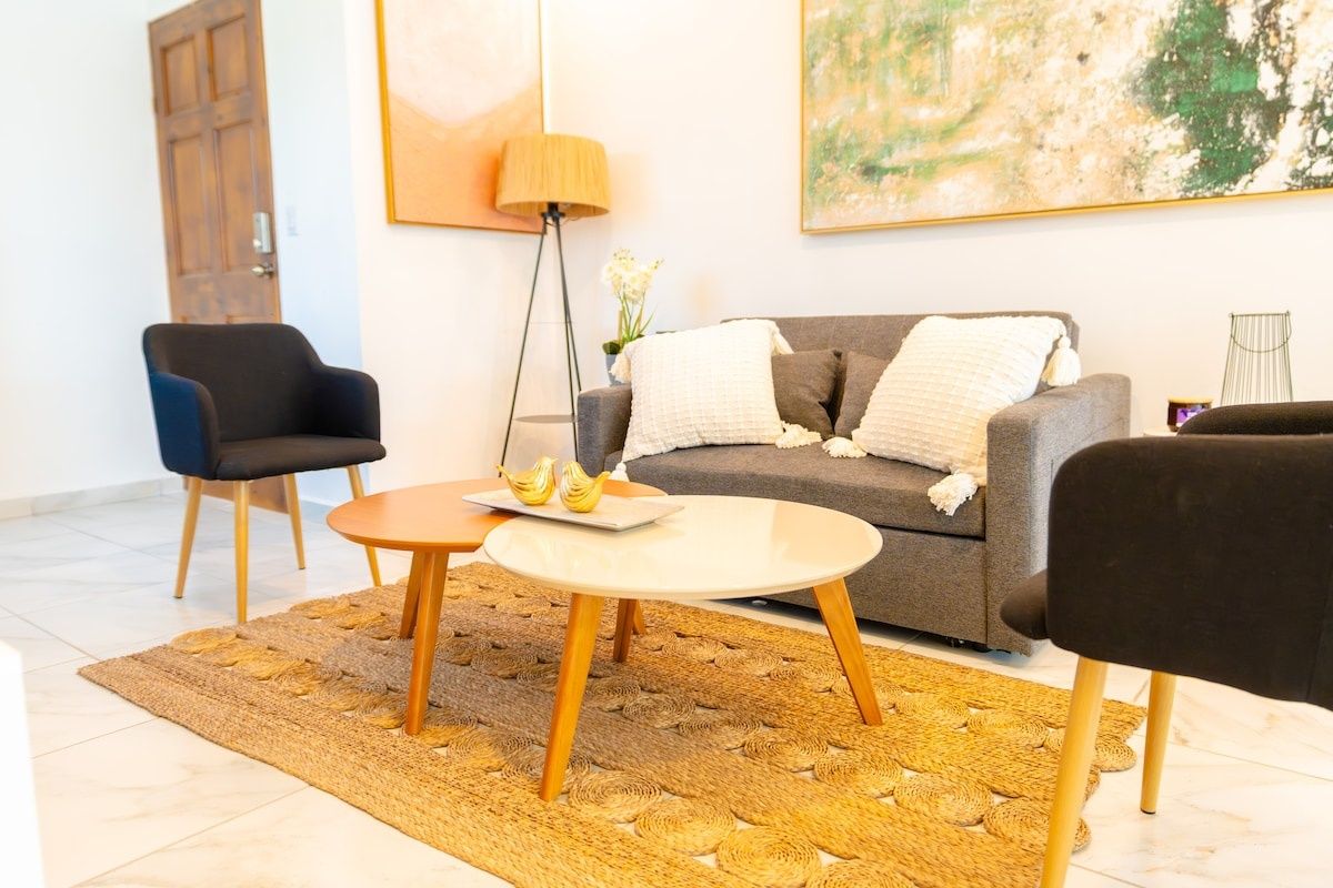En stue med sofa, to lænestole, sofabord og gulvlampe.