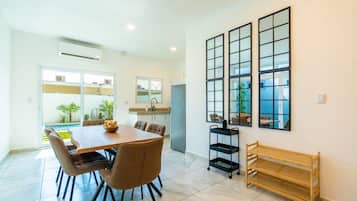 Una cocina moderna con comedor, ventanas amplias y vistas al exterior.