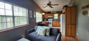 A compact living space with a sofa, a dining table, and a kitchenette. - Quiet 2BR Treehouse Loft Near Downtown Tahlequah (Tahlequah)