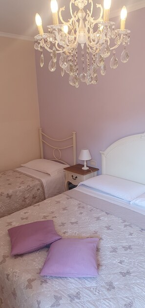 A bedroom with two beds, a chandelier, and a bedside table with a lamp. - Located near the Marmore Falls, Villa Maria welcomes you to the Umbrian hills (Umbria)