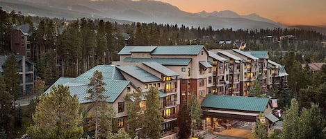 A multi-story hotel with a modern architectural design, featuring a central courtyard and multiple balconies.