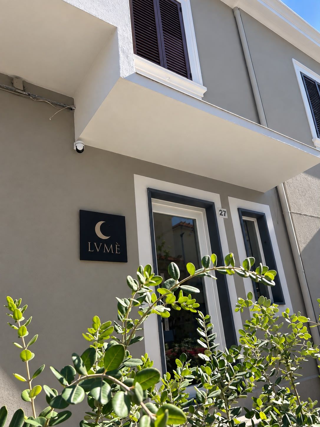 A building facade with a sign reading 'LVME' and a door with the number '27'.