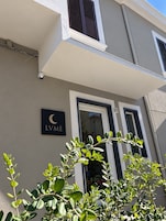 Fachada de um prédio com uma placa indicando 'LVME' e uma porta com o número '27'.