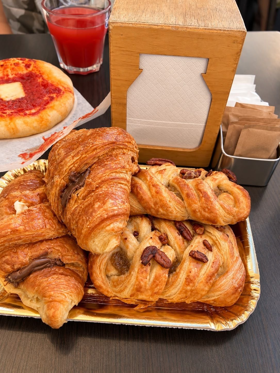 Een schaal gebakjes en een pizza op een tafel.