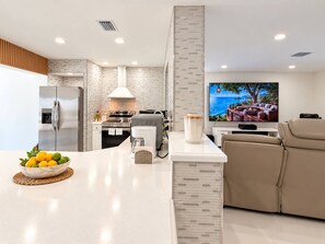 A modern kitchen with a built-in oven, a refrigerator, and a coffee maker on the counter. - Private Pool BBQ Outdoor Dining (Hollywood)