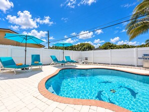 A swimming pool with lounge chairs and umbrellas, surrounded by a white fence and palm trees. - Private Pool BBQ Outdoor Dining (Hollywood)