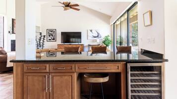 A kitchen with a central island, wooden cabinets, a built-in oven, and a ceiling fan.