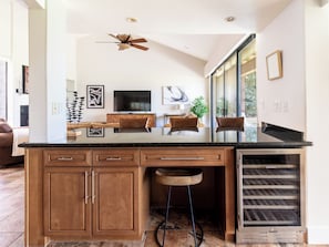 A kitchen with a central island, wooden cabinets, a built-in oven, and a ceiling fan. - Country Club Condo w/ Fairway Views + 37 Pools (Palm Desert)