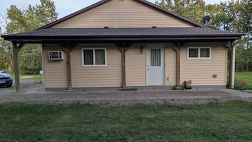 A single-story house with a gabled roof, a front door, and two windows.