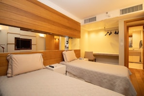 A hotel room with two beds, a mirror, a TV, and a bathroom visible through an open door. - Apartment with Office and Pool in the Hotel District (Brasilia)