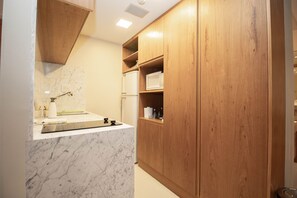 Ein Badezimmer mit Marmorplatte, Holzschränken und einem integrierten Waschbecken.