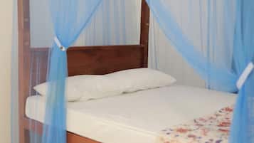 A bed with a wooden headboard, a white mattress, and a blue canopy.