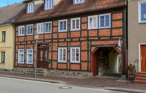 A traditional half-timbered building with multiple windows and a door, situated on a street corner. - Beautiful apartment in Röbel with WiFi (Röbel)