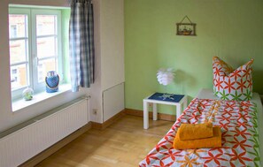 A room with a bed, a window with curtains, a small table with a lamp, and a radiator. - 2 bedroom lovely apartment in Röbel (Röbel)